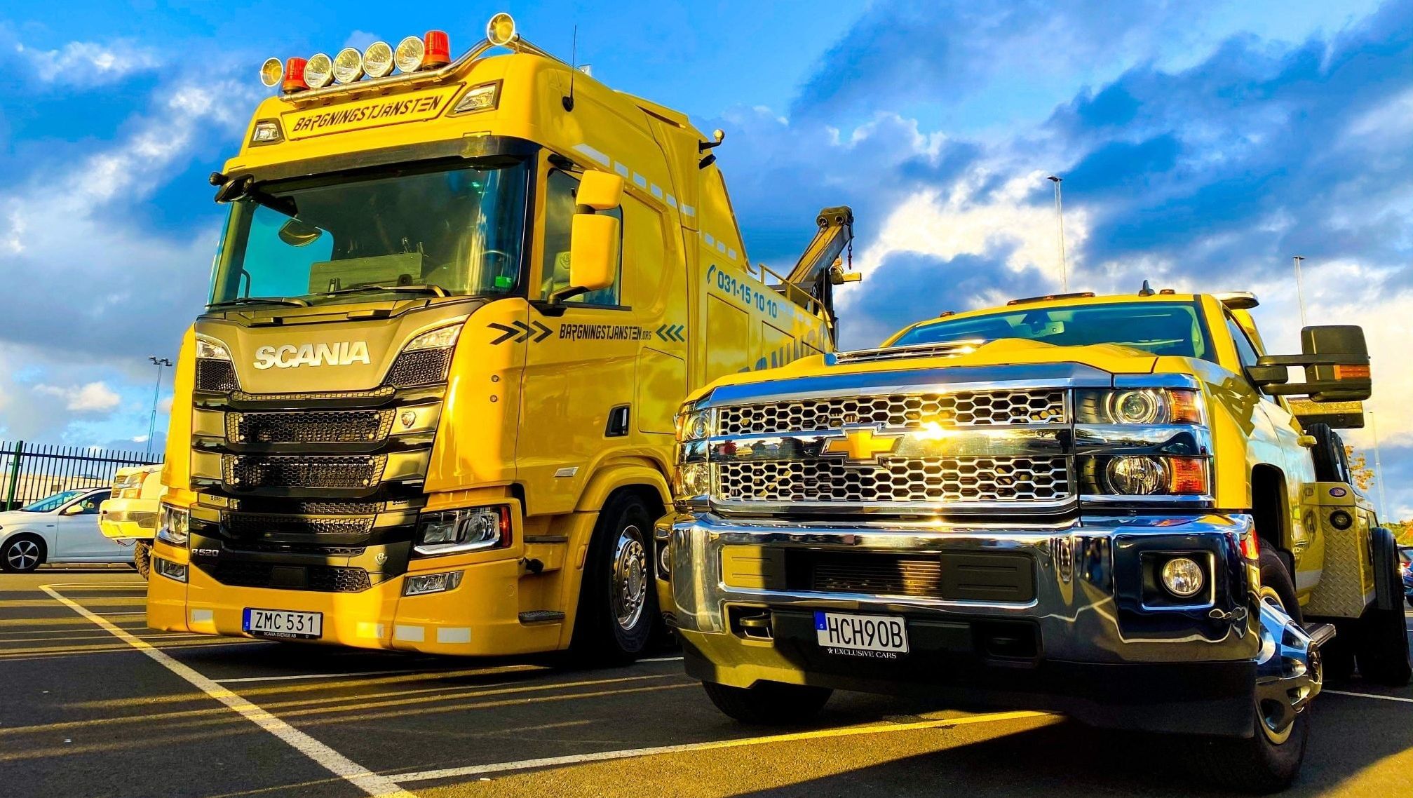 Gul bärgningslastbil och gul bärgningsbil från Bärgningstjänsten i Göteborg, och som hjälper till att transportera skrotbilar 